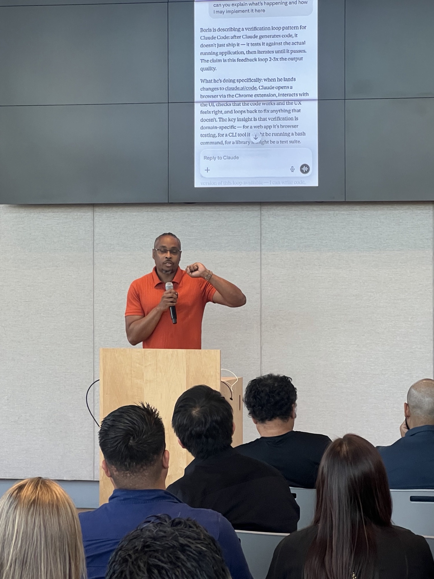 Kenan speaking to the room with a microphone during an AI working session